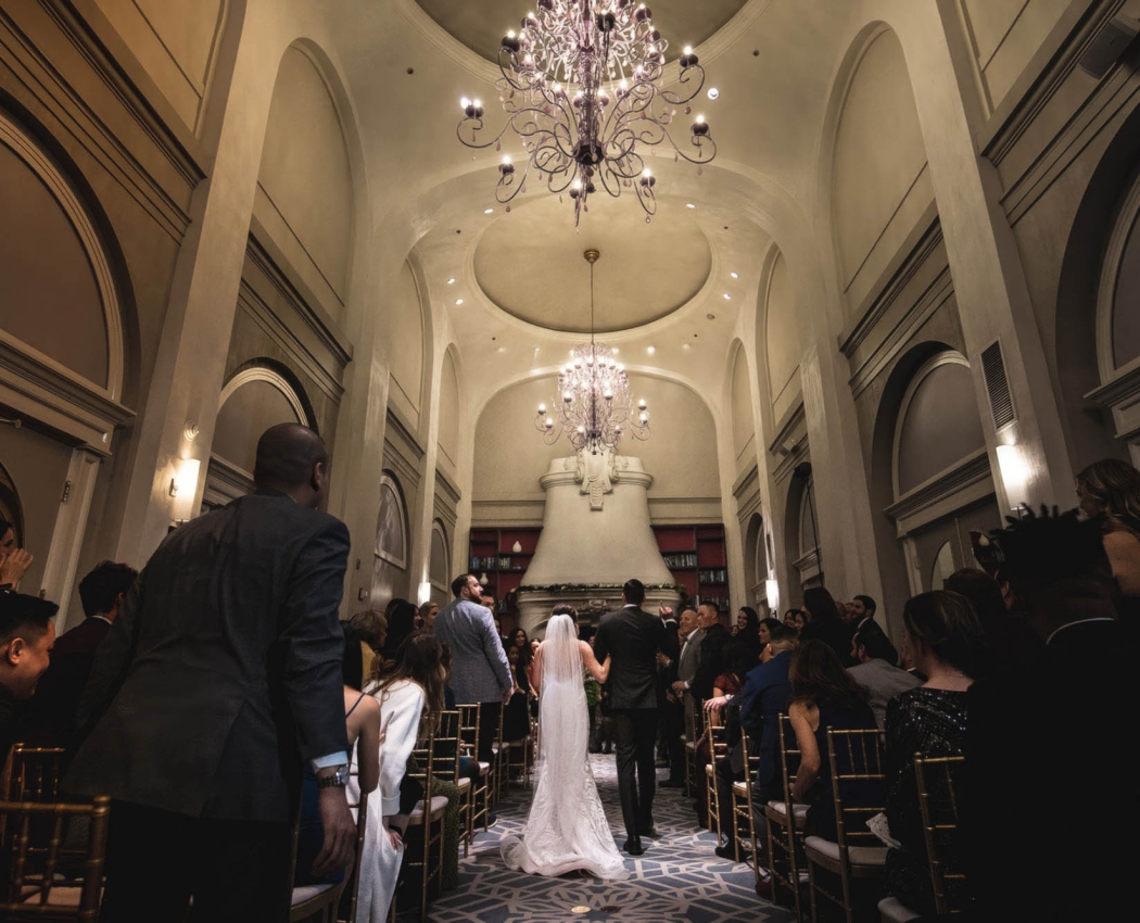 A bride and groom walking down the isle in a wedding venue at The Marker