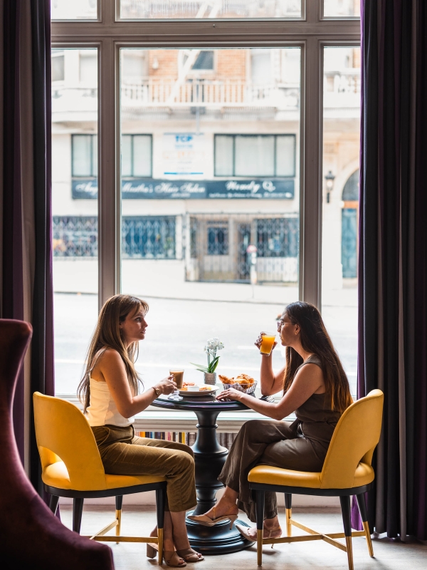 2 people enjoying lunch while sitting in front of a window at The Marker
