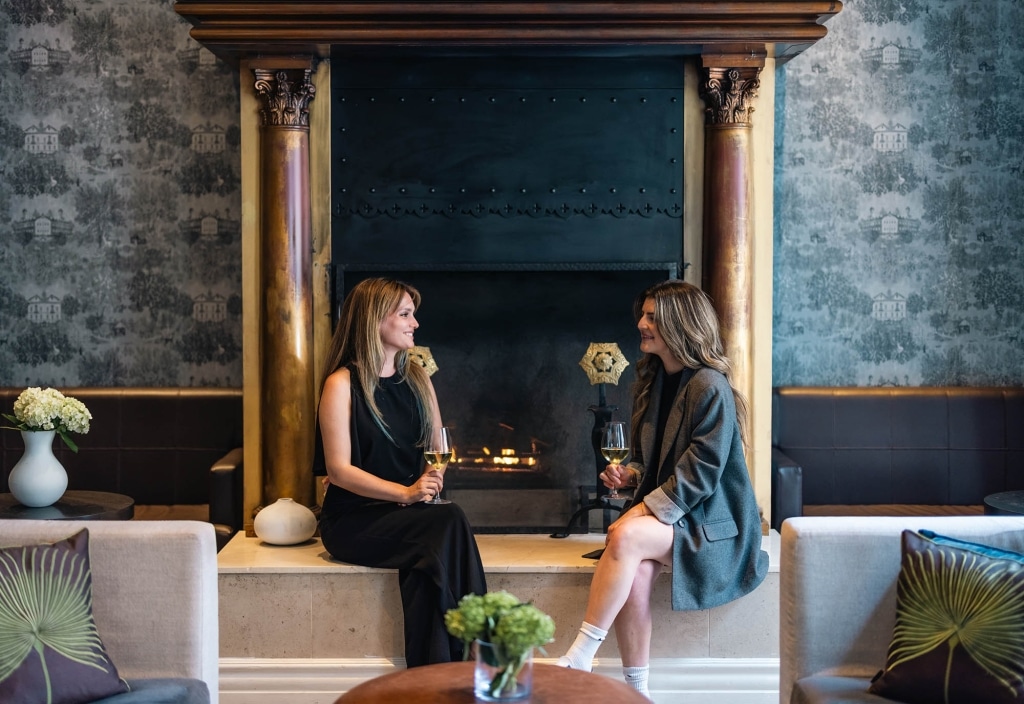 Two women enjoying drinks and chatting at The Marker