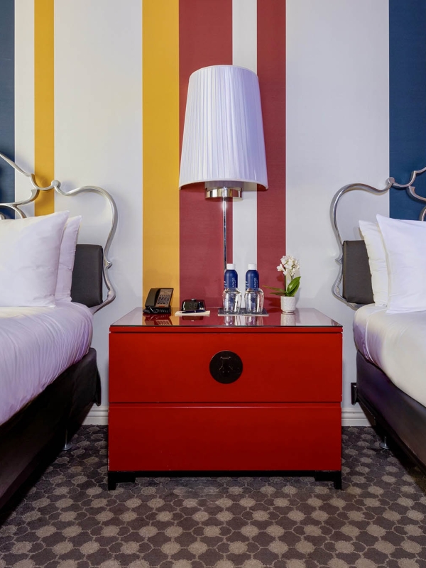 Two beds with a red dresser in the middle at The Marker